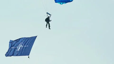 Close shot of Paratrooper skydiving with big NATO flag Stock-Footage 337204296