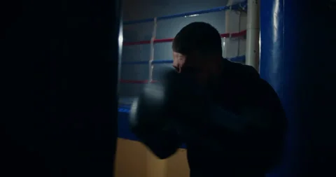 Close-up shot of persistent male athlete punching bag training hands muscles 库存影片 150059983
