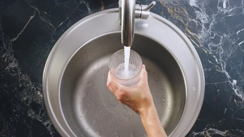 Close up shot person hand using faucet opening tap with clean water filling full Vidéo 322821034