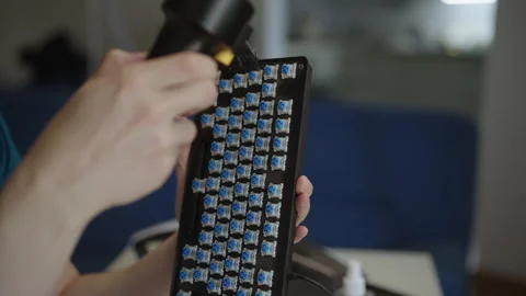 Close-up shot of person hands using handheld air duster to blow dust from blue Stock Footage 342811167