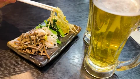 A close up shot of a person picking bean sprouts with chopsticks from a pla.. Vídeos de archivo 333078925