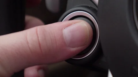 A close up shot of a person starting the engine of a car on the start button Stock Footage 104562861