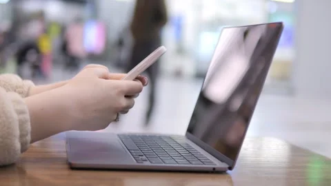 Close-up shot of person using phone beside laptop Stock Footage 340939129