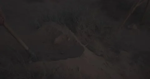 Close up shot for person using shovel digging grave in the desert at dusk Stock Footage 164615041