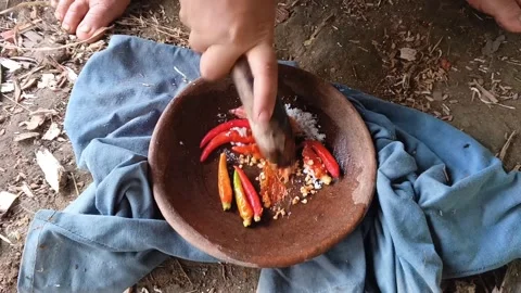 Close-up shot of a person's hand grinding red chili peppers and salt. Stock Footage 321934193