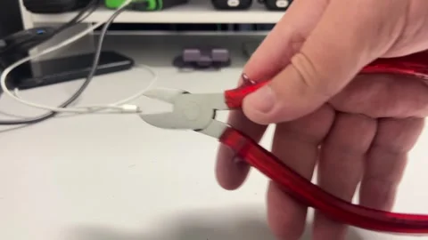 A close-up shot of a person's hand holding a pair of red and silver cutting.. Video stock 322982561