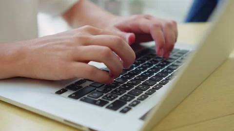 Close up shot of a person's hands actively typing on the keyboard of a silv.. Stock Footage 339858362