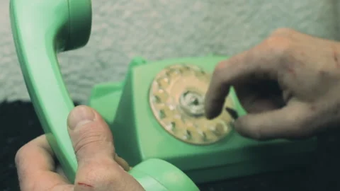 Close-up shot of a person's hands using a retro green rotary telephone Vídeo Stock 336932045
