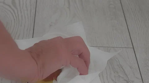 Close up shot of a person's hands using a white paper towel to wipe a messy Видео 342278471