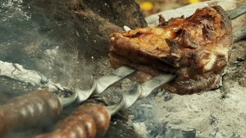 A close-up shot of a piece of meat being grilled over a campfire. The meat .. Stock Footage 300889972