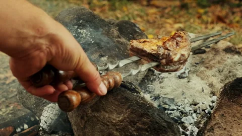 A close-up shot of a piece of meat being grilled over a campfire. The meat .. Stock Footage 300891047