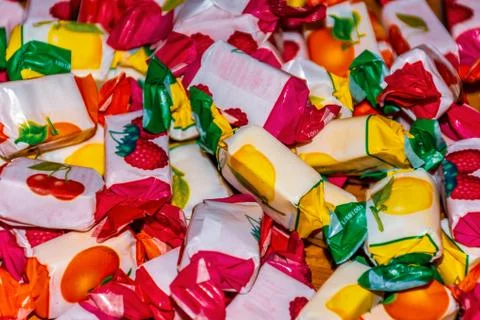A close-up shot of a pile of assorted chewing sweets with fruit flavors in th Stock Photos