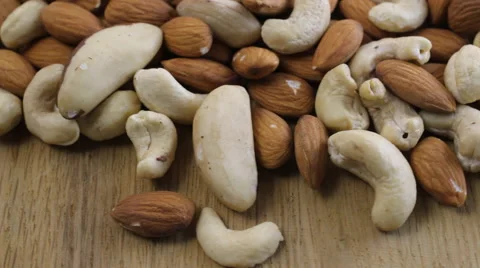 Close up shot of a pile of nuts rotating on wooden table Stock-Footage 60403571