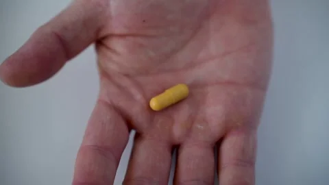 Close up shot of pill in opening Hand. The hand is holding pill, top view Stock Footage 275474062