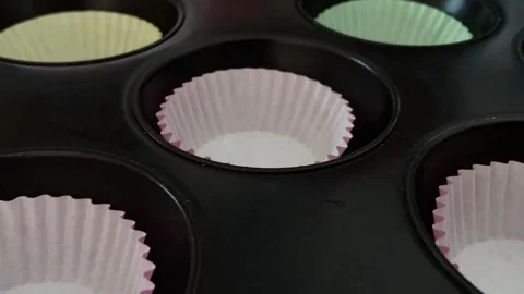 Close-up shot placing empty colored paper cups on a baking tray for preparing Stock Footage 267733335