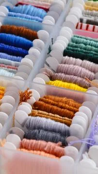 Close-up shot of a plastic box filled with colorful embroidery floss wound on Stock Photos