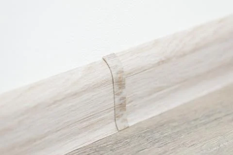 Close up shot of plinth between white wall and linoleum floor Stock Photos