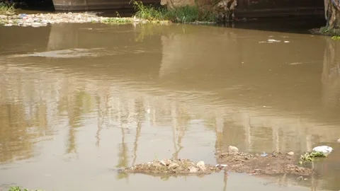 Close shot of polluted water, View of polluted water flowing in river Видео 148540299