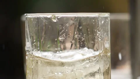 Close shot of poring ice cube in a glass filled with wine Stock Footage 148265641