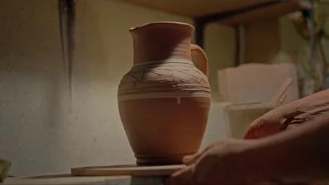 Close up shot of a potter's hands finished clay jug. Craftsman cuts clay bowl Stock Footage 264099339