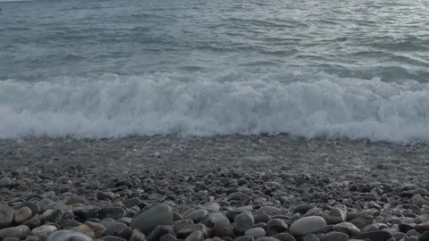 Close-up shot of powerful sea wave crashing onto pebble beach Stock Footage 336178630