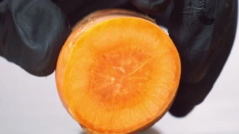 Close up shot of preparing carrot. Chef in black gloves slice carrot on round Video stock 150772152
