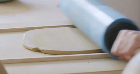 Close up shot of preparing clay for pottery, rolling with a wooden roller, Stock Footage 279530630
