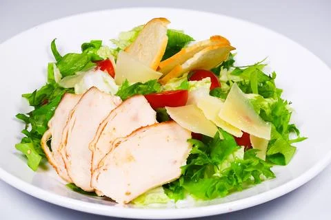 Close-up shot presenting a light chicken Caesar salad with croutons and Parme Foto stock
