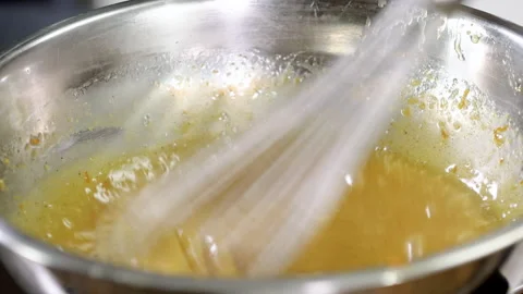Close-up shot of professional chef mixing eggs and butter with whisk in bowl. 4K Vídeo Stock 136845780