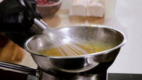 Close-up shot of professional chef mixing eggs and butter with whisk in bowl. 4K 库存影片 136845804