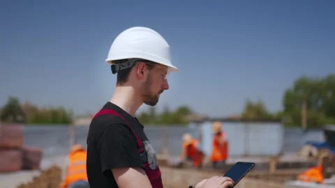 Close up shot of Professional Construction Worker Wearing Hard Hat Holds Tablet Stock Footage 258798602