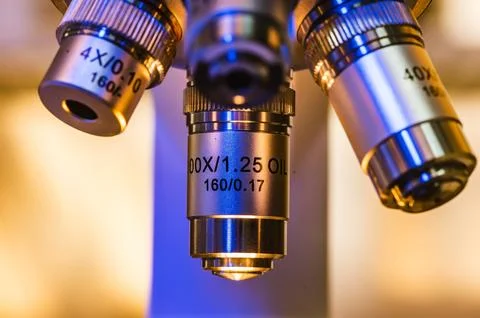 Close-up shot of professional scientific microscope with metal lens setting.. Photos