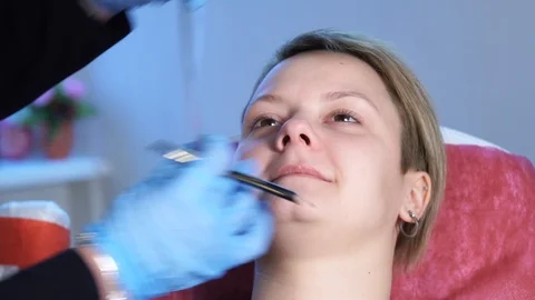 Close up shot. Professional specialist of permanent make-up applying eyebrow Stock Footage 85616853