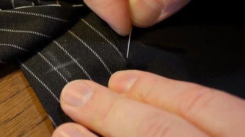 Close up shot of professional Tailor sewing vent with needle and thread. striped Stock Footage 127570668