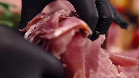 Close-up shot of prosciutto slices in hands of person with black gloves Stock-Footage 269999201