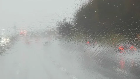 Close-up shot of rain drops and streaks on the window od moving bus by highway Stock Footage 101078925
