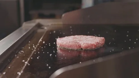 Close up shot of raw beef cutlet for burger frying on electric commercial grill. Stock Footage
