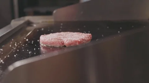 Close up shot of raw beef cutlet for burger frying on electric commercial grill. Stock Footage 80675820
