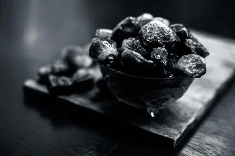 Close up shot of raw dried dates in a glass bowl on a wooden surface with som Stock Photos