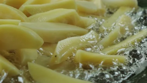 Close up shot of raw potatoes fried in oil in a pan Stock-Footage 130659904