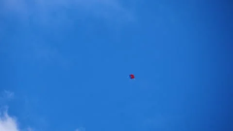 Close up shot of red and blue colored kite flying in a blue sky with clouds Stock Footage 258635155
