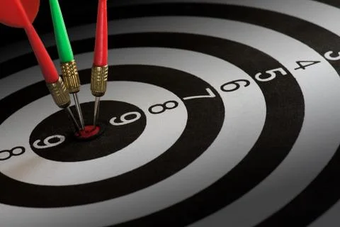 Close up shot red and green dart arrows on center of dartboard, metaphor to t Stock Photos