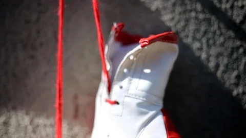 Close-up shot on red boxing gloves hanging on a rough concrete wall Video stock 105648531