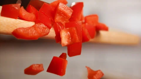 Close up shot of red chopped pepper falling in slow motion Stock Footage 153465014