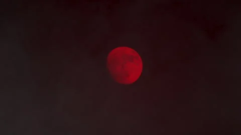 Close up shot of red full Moon in dark skies with swirling mist 스톡 동영상 286242032