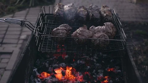 Close-up shot of red meat and chicken legs grilled during picnic Video stock 84254460