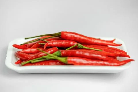 Close-up shot of red peppers on a white background. Fresh food ingredients co Stock Photos