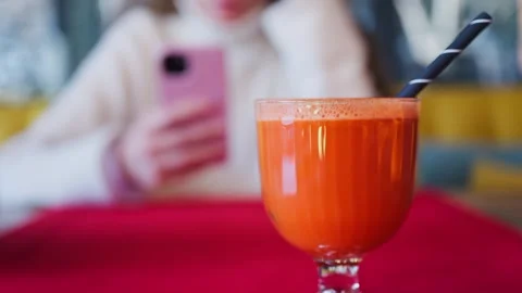 A close-up shot of a refreshing carrot juice in a glass, with a woman using.. Stock Footage 339213030