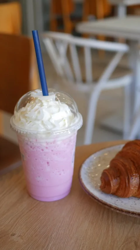 A close-up shot of a refreshing pink milkshake with whipped cream and a blu.. Stock Footage 333032492
