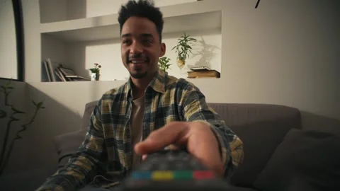 Close-up shot of remote control taking by handsome African man. Stock Footage 302066619